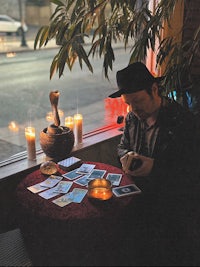 a man sitting at a table with candles