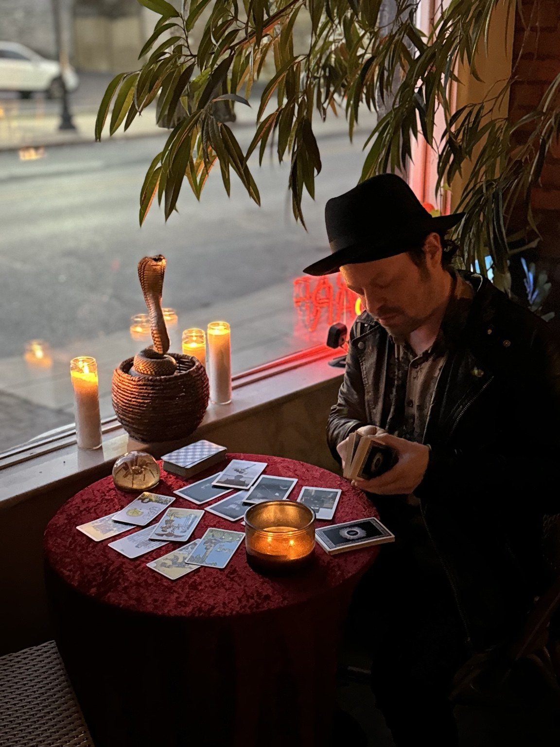 Colonel Moonlight reading tarot beside a candlelit window